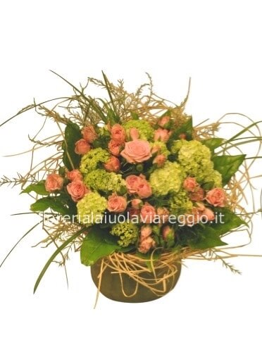 Cestino di vimini o ciotola di ceramica, composto da rose e verde pregiato.